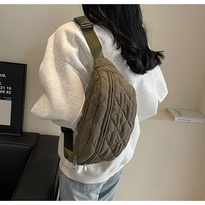 Detail showing army green quilted crossbody bag texture and adjustable strap on a model