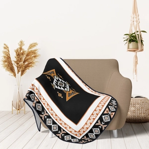 Detail of bohemian flannel blanket with geometric tribal patterns on a cozy beige sofa