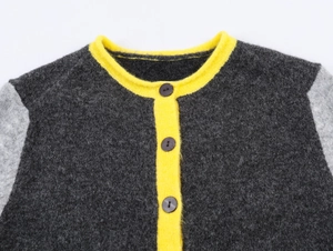 Detail of color-block knit cardigan showing fuzzy wool texture and round neck buttons