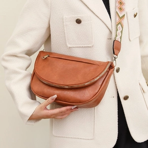 Detail of vintage brown leather crossbody bag with a geometric pattern woven strap