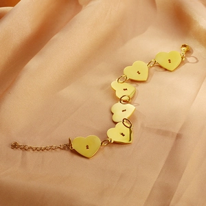 Détail d'un bracelet en plaqué or 18 carats avec pendentifs en forme de cœur évidé