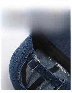 Detail of blue denim baseball cap featuring adjustable silver metal buckle closure