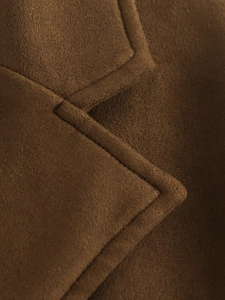 Détail d'un blazer en daim caramel montrant la texture du tissu et les coutures nettes