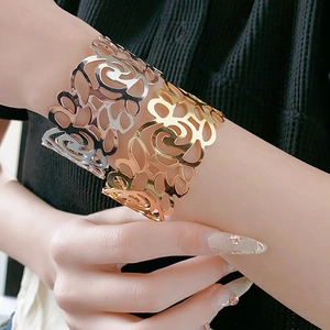 Detailed view of hollow vine patterns on gold and silver wide open bangles