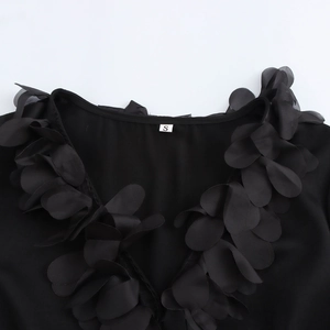 Elegant black V-neck top featuring intricate 3D floral petal appliques on the neckline