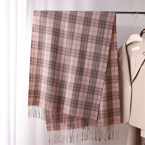 Pink and brown plaid cashmere-like scarf with tassels hanging near a beige blazer