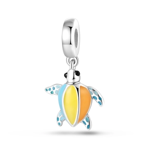 Macro shot of silver sea turtle pendant with colorful enamel shell and blue limb dots