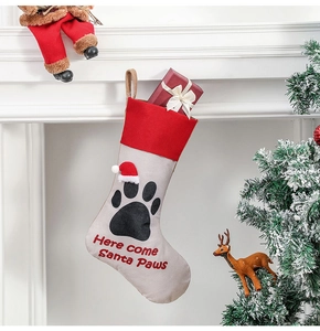 Beige linen pet Christmas stocking with red cuff and Santa Paws embroidery on fireplace
