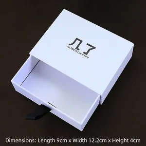 White drawer-style jewelry box with black ribbon handle, dimensions 9cm x 12.2cm x 4cm