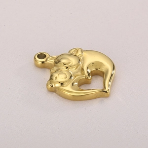 Detail of golden stainless steel heart pendant with two cuddling animals on gray fabric