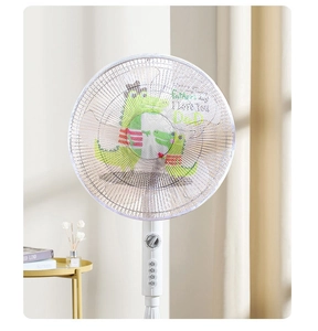 Detail view of white electric fan safety cover with green cartoon crocodile pattern