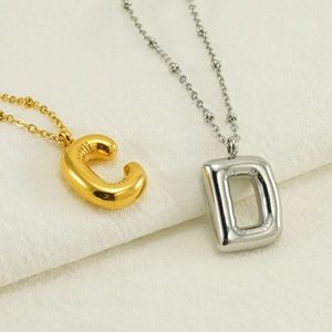 3D balloon initial pendant necklace in gold and silver with puffed stitch details