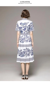 Vue arrière d'une robe mi-longue blanche avec imprimés floraux bleus et taille cintrée