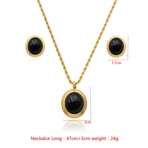 Detailed view of gold rope chain necklace and black stone earrings jewelry set