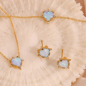 Detailed close-up of gold-plated heart-shaped opal pendant and matching stud earrings