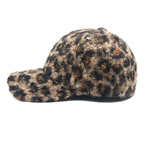 Side view of leopard print faux shearling baseball cap with curly textured plush fabric