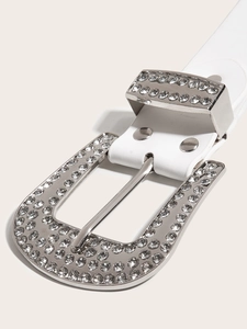 Gros plan sur la boucle argentée ornée de strass brillants d'une ceinture punk blanche
