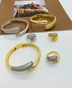 Flat lay of gold and silver plated open bangles and rings with micro pave cubic zirconia
