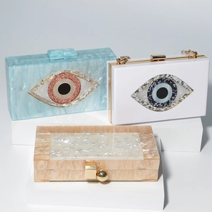 Detailed view of luxury acrylic evening bags featuring blue and white marble evil eye designs