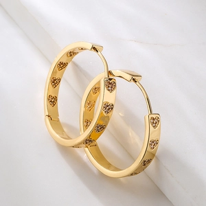 18K gold plated hoop earrings with heart-shaped zircon stones on marble background