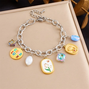 Detail of stainless steel multi-charm bracelet with tulip and star pendants on a display