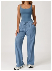 Detail of high-waisted loose sports trousers in blue with drawstring and leg seam
