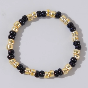 Minimalist hand-strung bracelet with glossy black beads and gold-plated accents