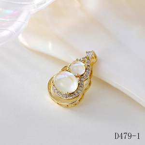 Macro shot of gold gourd pendant with moonstone and pavé zircon on shell background
