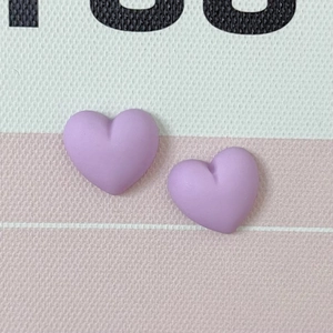 Macro shot of two purple macaron-style resin hearts for DIY phone cases and hair accessories