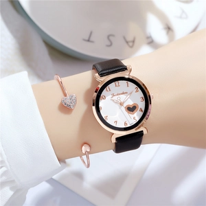 Close-up of women's quartz watch with black leather strap and matching heart bracelet