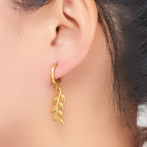 Golden wheat leaf drop earrings in stainless steel on model showcasing vintage style