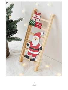 Detail of wooden Christmas ladder ornament with Santa Claus and gift box graphics