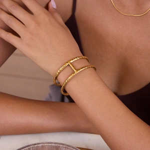 Close-up of golden hammered double-layer stainless steel bangle on a female wrist