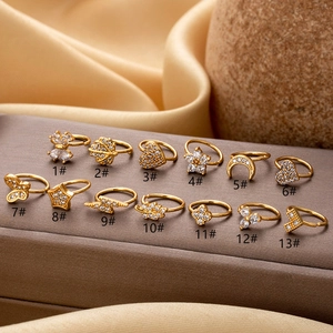 Detailed macro set of thirteen golden nose rings featuring butterfly and heart shapes
