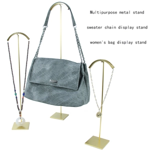 Three-piece gold metal display stands for handbags and necklaces on a white background