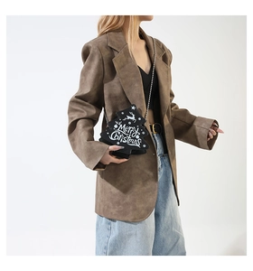 Side view of a Christmas tree shaped black crossbody bag with chain strap on a model