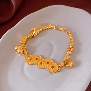Traditional Chinese style gold plated bracelet with ancient coins and gourd charms on tray