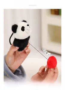 Detail of panda plush charm featuring a retractable red pom-pom heart for interactive fun