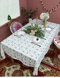 Detailed Christmas tablecloth with festive tree prints and holiday decor on table