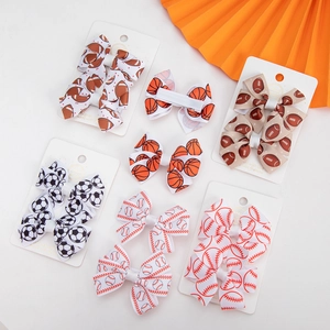 Detailed view of children's sports theme hair bows featuring soccer and football prints