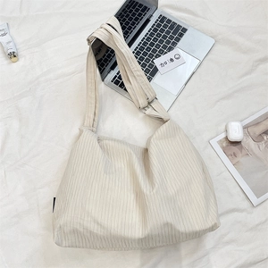 Detail of off-white canvas tote bag featuring striped texture and adjustable shoulder strap