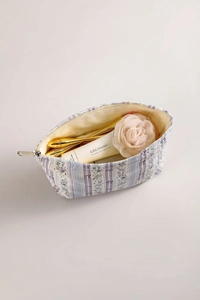 Detail view of large purple floral makeup bag showing interior storage and floral pattern