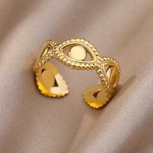 Detailed macro view of 18k gold plated evil eye adjustable ring on champagne satin fabric