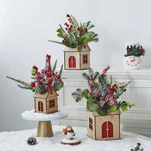 Mini lighted wooden Christmas house with red berries and pine needles for table decor