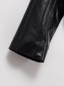 Close-up of black faux leather jacket cuff showcasing smooth texture and fine stitching