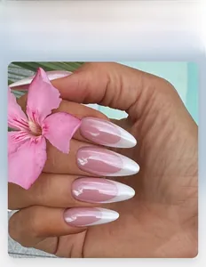 Detail of French style almond press-on nails with nude pink base and white tips