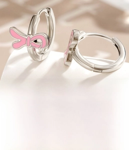 Macro detail of silver bow earrings with pink enamel coating and 10mm inner diameter