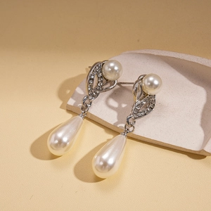Detail of silver drop earrings featuring elegant pearls and sparkling rhinestones