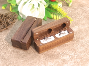 Macro detail of black walnut wood double ring box with soft white velvet lining for two rings