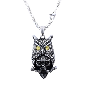 Vintage owl skull pendant in polished stainless steel with yellow gem eyes on white background
